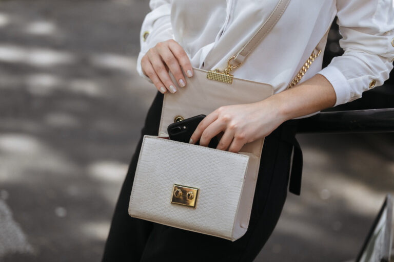woman-opens-cream-handbag-outdoors.jpg